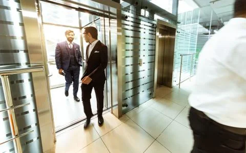 Business team group going on elevator. Business people in a large glass elevator Stock Photos