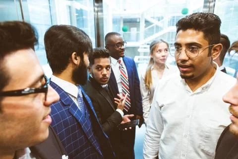 Business team group going on elevator. Business people in a large glass elevator Stock Photos