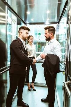 Business team group going on elevator. Business people in a large glass elevator Stock Photos