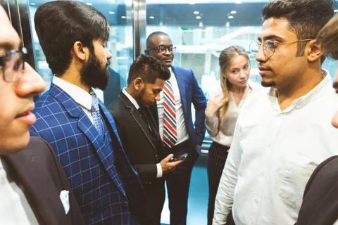 Business team group going on elevator. Business people in a large glass elevator Stock Photos