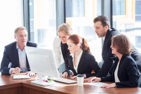 Business team look at one computer monitor Stock Photos