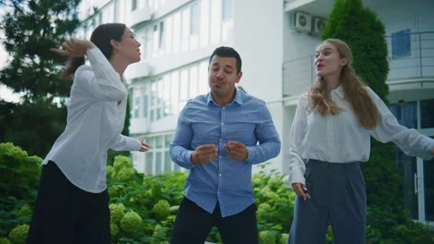 Business team members engaging in a fun dance activity outdoors during a work Stock Footage 344917089