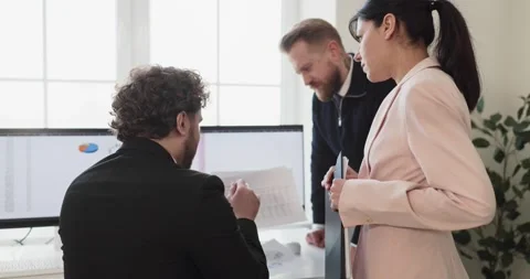 Business team reviewing audit data on computer monitors at strategy meeting Stock Footage 336616186