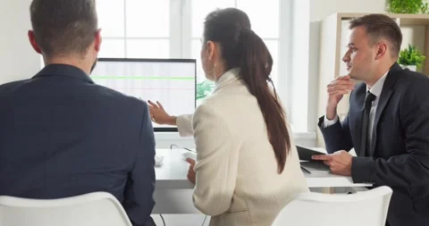 Business team reviewing data on computer during strategy meeting in modern Stock Footage 325977967