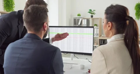 Business team reviewing data on computer during strategy meeting in modern Stock Footage 348568000