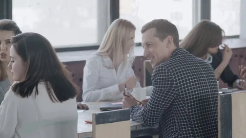 A business team is sitting at a large table and discussing a project. Employees Stock Footage 124551914