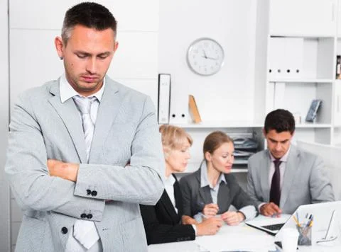 Business team solving problems with upset man foreground Stockfoto's