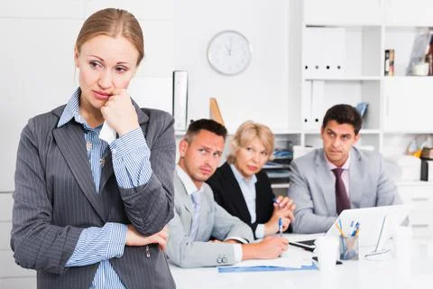 Business team solving problems with upset woman foreground Stock Photos