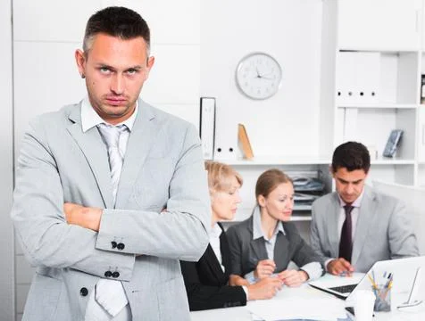 Business team solving problems with upset man foreground Stock Photos