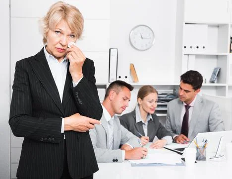 Business team solving problems with upset woman foreground Foto stock