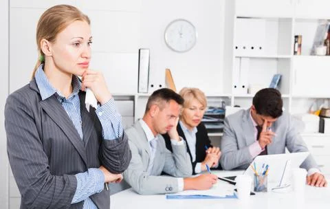 Business team solving problems with upset woman foreground 库存照片