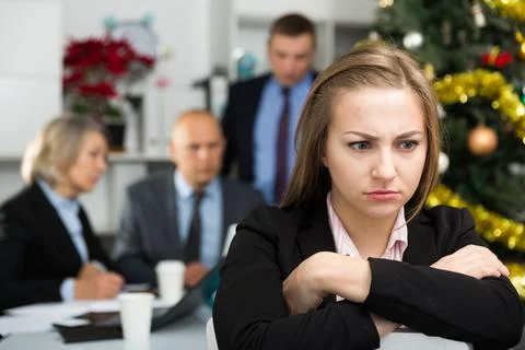 Business team tensely solving problems in office with upset woman foreground 写真素材