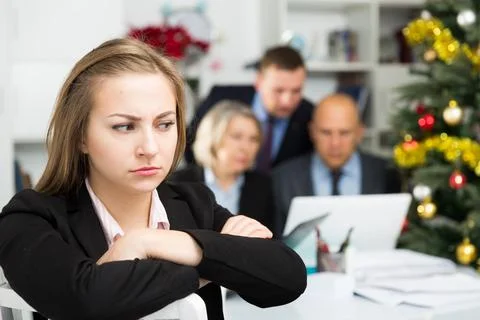 Business team tensely solving problems in office with upset woman foreground Stock Photos