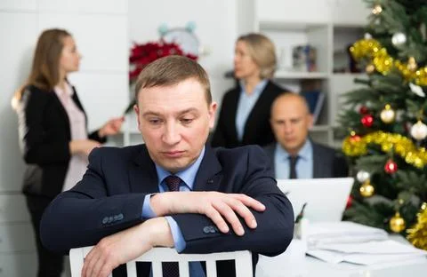 Business team tensely solving problems in office with offended man foreground Foto stock