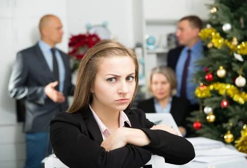 Business team tensely solving problems in office with upset woman foreground 库存照片