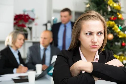 Business team tensely solving problems in office with upset woman foreground 库存照片