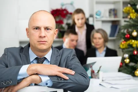 Business team tensely solving problems in office with offended man foreground Foto stock
