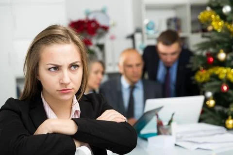 Business team tensely solving problems in office with upset woman foreground Stock Photos