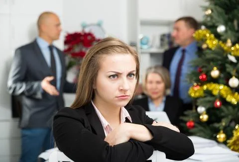Business team tensely solving problems in office with upset woman foreground Foto stock