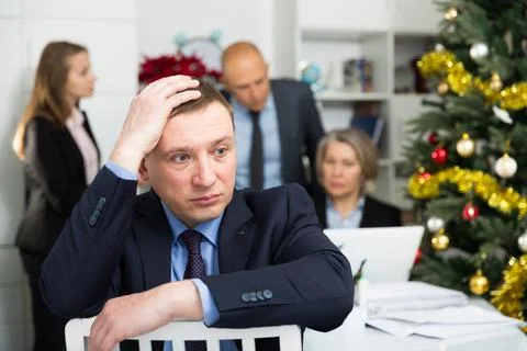Business team tensely solving problems in office with offended man foreground 库存照片
