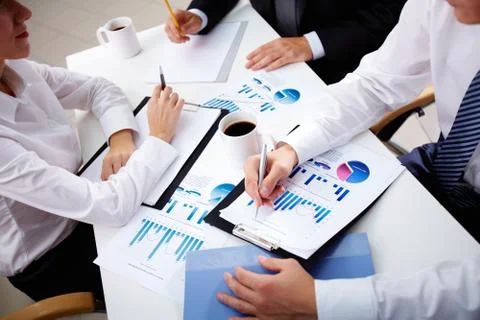 Business team of three analyzing statistical data Stock Photos