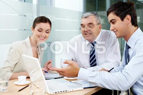 A business team of three sitting in office and planning work Stock Photos