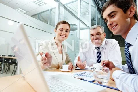 A business team of three sitting in office and planning work Stock Photos