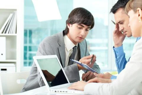 A business team of three sitting at table and planning work Stock Photos