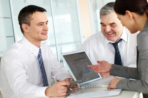 A business team of three sitting at table and planning work Stock Photos