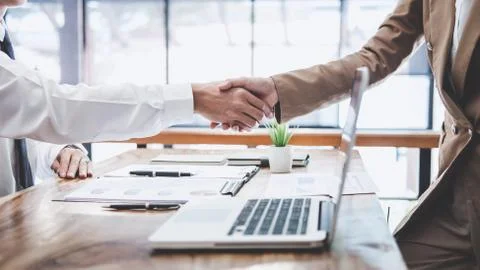 Business team two executive shaking hands after a meeting and conference to s Stock Photos