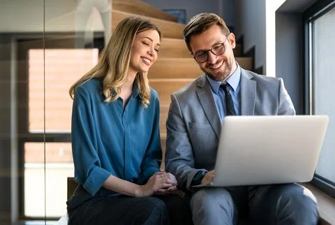 Business team of two executives working together using laptop in office. Te.. Stock Photos
