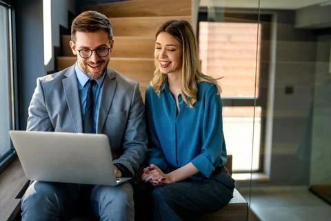 Business team of two executives working together using laptop in office. Te.. Stock Photos