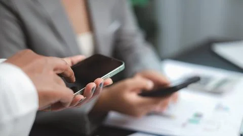Business Team Using Smartphone for Communication and Data Sharing Stockfoto's