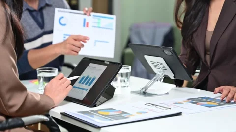 Business team working with digital tablets and reports in a modern office. .. Stock Footage 312439842