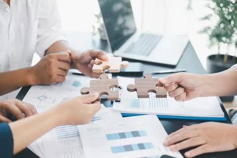 Business teamwork concept with people holding wooden puzzle pieces together.. Stock Photos