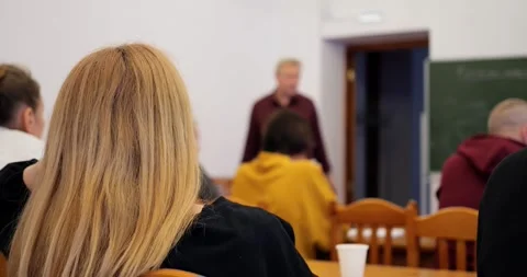 Business trainer conducting workshop with professionals seated around, sharing Stock Footage 296326417