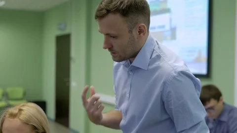 Business trainer gesturing explains managers working principle. Mentor shows on Stock Footage 70739368