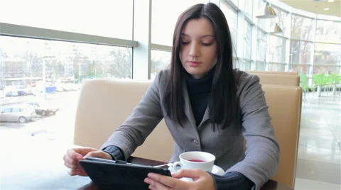 Business woman drinking coffee and working on a tablet Stock Footage 59777531