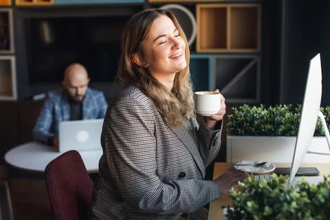 Business woman drinks coffee in the office at the work table Stock Photos
