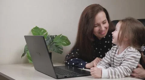 Business woman freelancer works at home with a laptop with a small child, mom Stock Photos