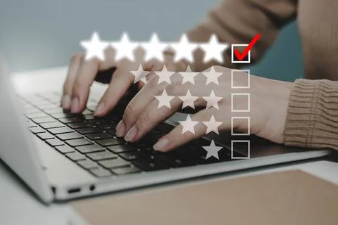 Business woman hand working on laptop with graphic checking mark 5 star Stock Photos