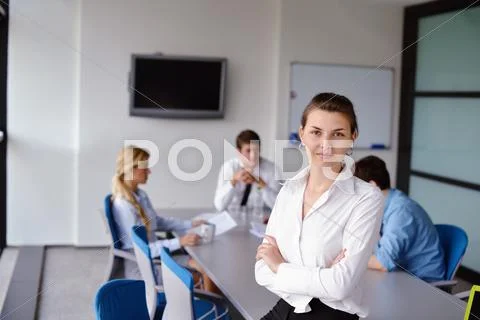 Business woman with her staff in background at office Stock Photos