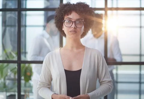 Business woman with her staff in background at office Stock Photos