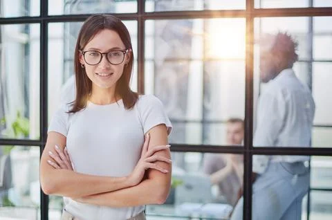 Business woman with her staff in background at office Stock Photos