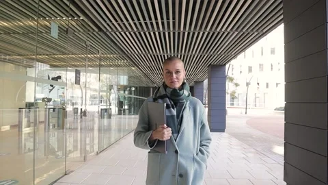Business woman looking at the camera while walking outside the office building Video stock 192318167