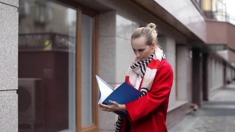Business Woman Looking Documents in a Folder Standing by the Office Stock-Footage 74694463