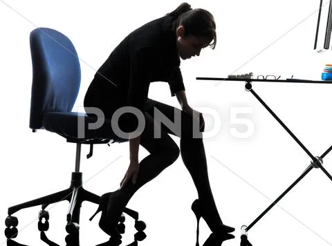 Business woman massaging her leg silhouette Stock Photos