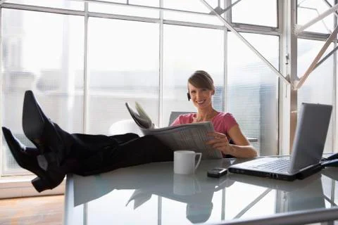 Business woman relaxing at her desk feet on table top Stock Photos