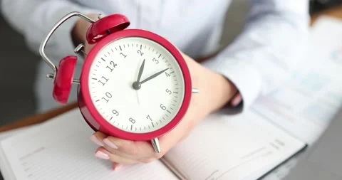 Business woman setting time on alarm clock in office closeup Stock Footage