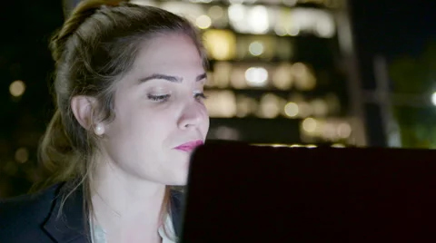 Business woman sitting in a cafe at night, working on a laptop computer Stock Footage 59172891